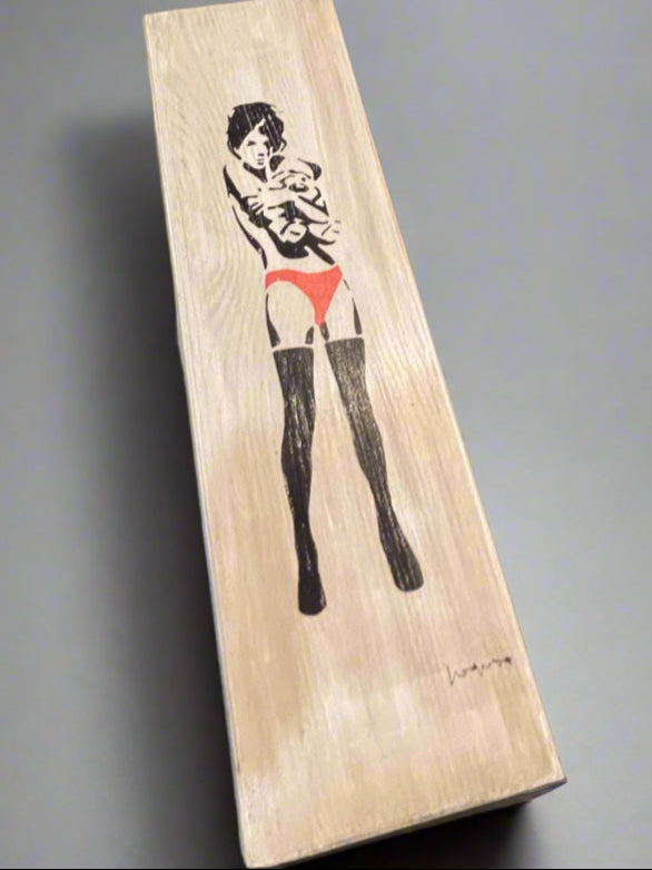 Wooden block with a woman's silhouette on a table with decorative items