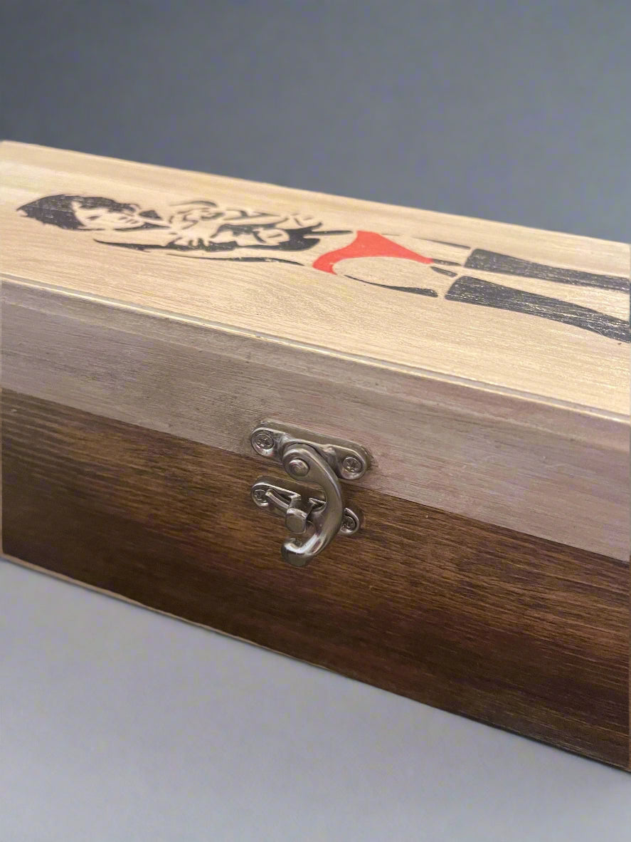 Wooden box with a metal clasp and decorative design on a blurred background