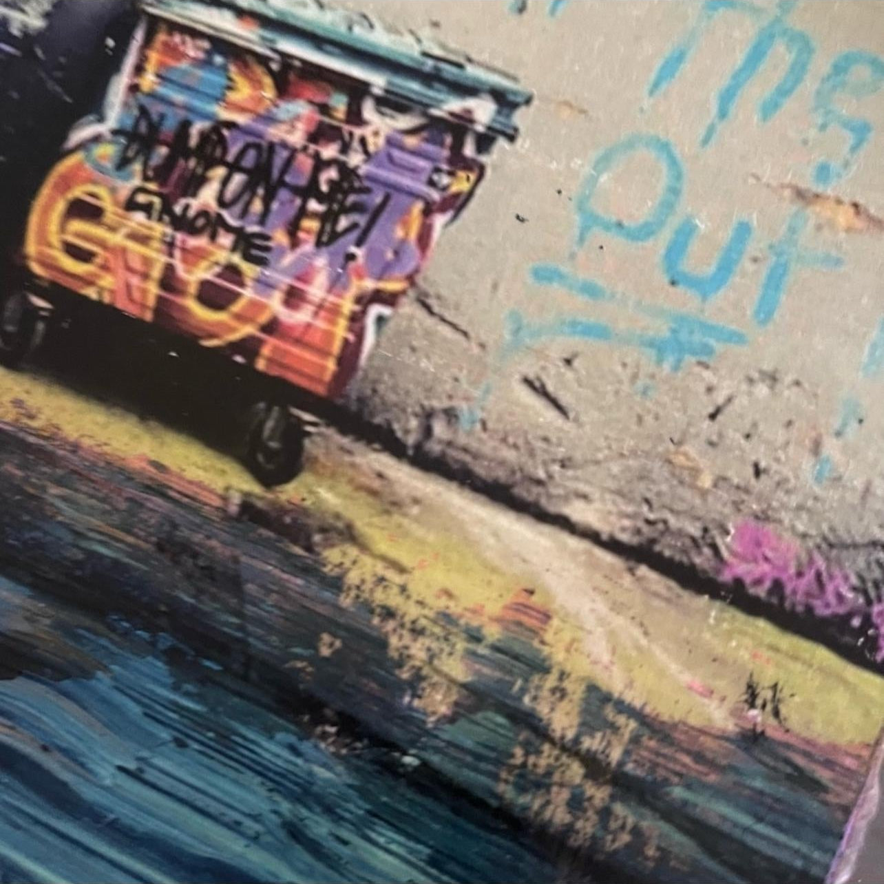Graffiti on a wall with a street scene below